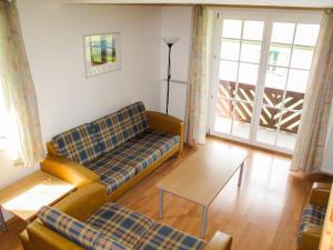 a living room with a couch and a table at Holiday Home Holiday Hill by Interhome in Lauterwasser