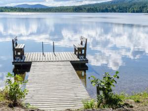 two benches sitting on a dock on a lake at Holiday Home Hiisiranta b3 by Interhome in Kolinkylä
