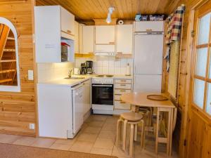 コリンカイラにあるHoliday Home Karjalan heili 17 by Interhomeのキッチン(白い家電製品、テーブル、椅子付)