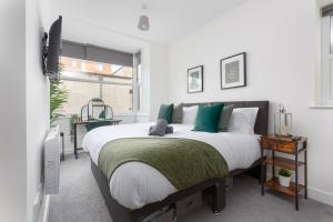 1 dormitorio con 1 cama grande con almohadas verdes en Charles Alexander Short Stay - Charnley House Apartments, en Blackpool