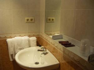 łazienka z umywalką i lustrem w obiekcie Hotel Grove w mieście O Grove