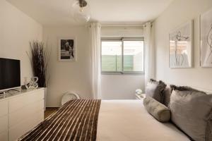 a white bedroom with a bed and a television at Stylish New 1 bedroom apartment in juan les pins in Antibes