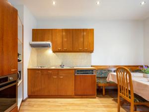a small kitchen with wooden cabinets and a table at Apartment Kolm by Interhome in Srejach