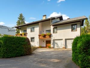 ein großes weißes Haus mit Auffahrt und Büschen in der Unterkunft Apartment Georgiberg by Interhome in Srejach