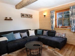 - un salon avec un canapé noir et une table dans l'établissement Chalet Felsenhütte by Interhome, à Ebene Reichenau