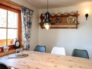 - une salle à manger avec une table et des chaises en bois dans l'établissement Chalet Felsenhütte by Interhome, à Ebene Reichenau
