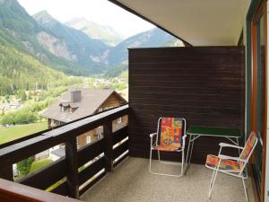 a balcony with two chairs and a table and a view at Studio Top 46 A by Interhome in Heiligenblut +19 photos