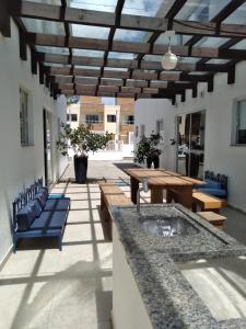 a patio with a wooden table and benches at Residencial Marbella in Bombinhas