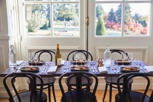 a dining room table with plates of food and wine glasses at Maison du Val - Les Maisons de Campagne in Saint-Germain-en-Laye