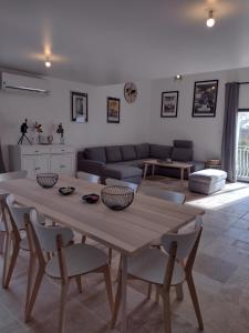 een woonkamer met een houten tafel en stoelen bij LES GITES DU LAUZON in Montségur-sur-Lauzon