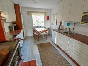 eine Küche mit weißen Schränken und einem Tisch mit einem Tisch in der Unterkunft Holiday Home Huitsin nevada by Interhome in Kangosjärvi + 10 Fotos