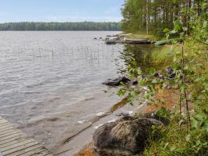 a body of water with a pier and a boat at Holiday Home Ulpukka by Interhome in Savilahti