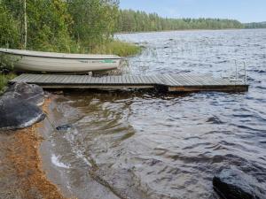 un barco sentado en un muelle en un lago en Holiday Home Ulpukka by Interhome, en Savilahti