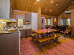 Cabaña con cocina y sala de estar con mesa. en Holiday Home Ulpukka by Interhome, en Savilahti