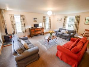 a living room with two couches and a table at Holiday Home Achalic Beag by Interhome in Lerags