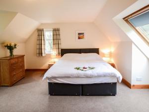 a bedroom with a large bed with flowers on it at Holiday Home Achalic Beag by Interhome in Lerags