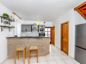 a kitchen with a brick counter and two stools at Holiday Home Yellow 2 by Interhome in Balatonmáriafürdő