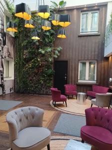 a lobby with purple and yellow chairs and a building at Hotel Aida Marais in Paris