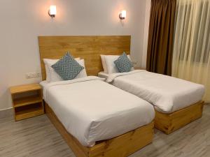 two beds in a hotel room with at Sky View by Relax Tours in Dhangethi