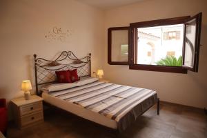 um quarto com uma cama com um espelho e uma janela em Casa Doci em Budoni