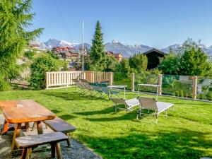 a group of picnic tables and chairs in a yard at Chalet Mirabeau by Interhome in Nendaz