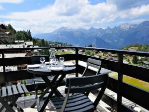 a table and chairs on a balcony with a view of mountains at Apartment Christiania 2 F7 by Interhome in Nendaz