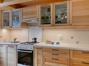 cocina con armarios de madera y horno con fogones en Holiday Home Rustico Nurell by Interhome en Madra