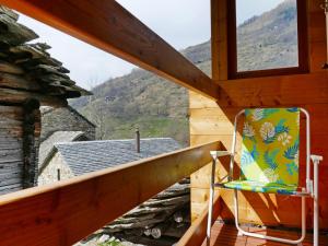 una silla en el balcón de una cabaña con vistas en Holiday Home Rustico Nurell by Interhome en Madra