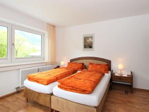 sypialnia z 2 łóżkami z pomarańczową pościelą i oknem w obiekcie Apartment Am Ziller by Interhome w mieście Hippach +37 zdjęć