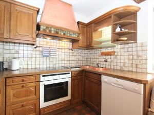 kuchnia z drewnianymi szafkami i białą płytą kuchenną w obiekcie Apartment Am Ziller by Interhome w mieście Hippach