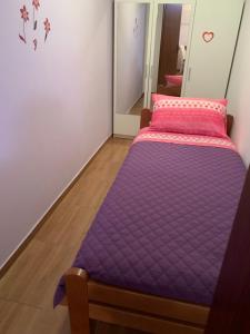 ein kleines Schlafzimmer mit einem lila Bett darin in der Unterkunft Apartment in family house Linda in Čavle