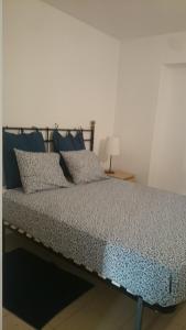 a bed with blue pillows on it in a room at Pis Firalet - Olot in Olot