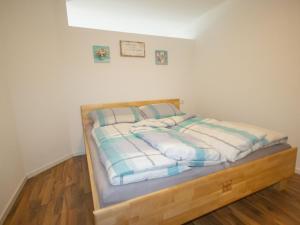 a bedroom with a bed with a wooden frame at Apartment Mundlers Hoamatl Top 1 by Interhome in Oetz