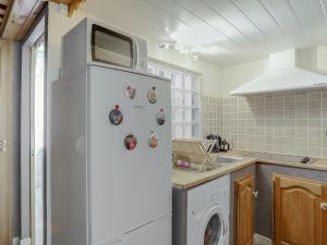 a white refrigerator in a kitchen with a washing machine at Apartment La résidence by Interhome in Saint-Gervais-les-Bains