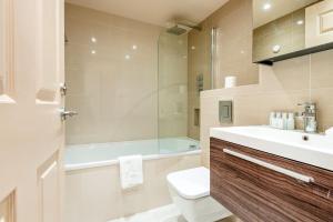 La salle de bains est pourvue d'une baignoire, de toilettes et d'un lavabo. dans l'établissement Stunning 3-bedroom in the heart of London with parking-hosted by Sweetstay, à Londres