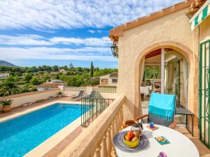 Eine Villa mit Swimmingpool und einem Tisch mit einer Obstschale in der Unterkunft Holiday Home Isabelle by Interhome in Jávea