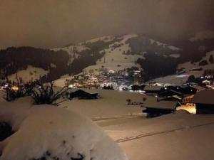 einen schneebedeckten Berg mit einer Stadt im Hintergrund in der Unterkunft Apartment Les Hivernants - EG links by Interhome in Gstaad