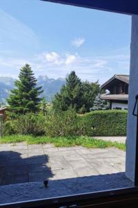 een raam met uitzicht op de bergen vanuit een huis bij Apartment Les Hivernants - EG links by Interhome in Gstaad