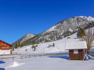 a snow covered mountain with a house and a fence at Apartment Chalet Alte Post by Interhome in Schwenden