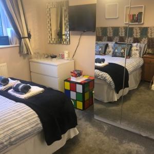 a bedroom with two beds and a mirror at Little Acorns in Saint Albans