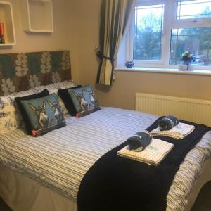 a bedroom with a bed with two phones on it at Little Acorns in Saint Albans