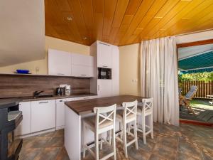 eine Küche mit weißen Schränken und einer Holzdecke in der Unterkunft Apartment Polgar by Interhome in Balatonmáriafürdő