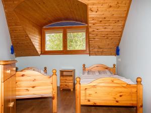 2 Betten in einem Zimmer mit Holzwänden in der Unterkunft Apartment Polgar by Interhome in Balatonmáriafürdő