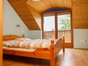 um quarto com uma cama de madeira e uma grande janela em Apartment Polgar by Interhome em Balatonmáriafürdő