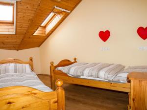 2 Betten in einem Zimmer mit Herzen an der Wand in der Unterkunft Apartment Polgar by Interhome in Balatonmáriafürdő