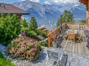 a wooden deck with a table and chairs and mountains at Chalet Le Muveran V8 by Interhome in Nendaz