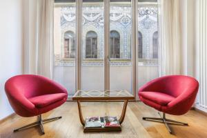 two red chairs and a table in front of a window at Luxury Pontevecchio 5 Stars Apartment in Florence +32 photos