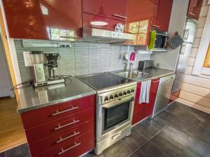 cocina con armarios rojos y fogones en Holiday Home Anttoora 1 by Interhome, en Pori