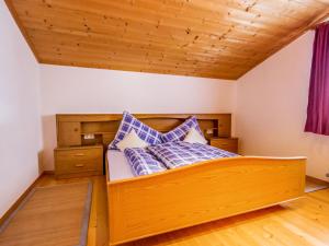 Bett mit blauen und weißen Kissen in einem Zimmer in der Unterkunft Apartment Anna by Interhome in Umhausen