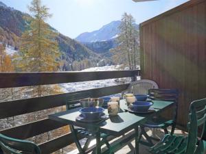 una mesa y sillas en un balcón con vistas en Apartment Mont-Fort-11 by Interhome, en Siviez